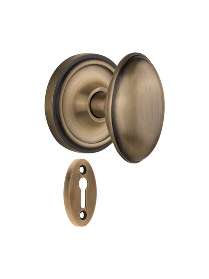 Classic Rosette Mortise-Lock Set with Homestead Knobs in Antique Brass.